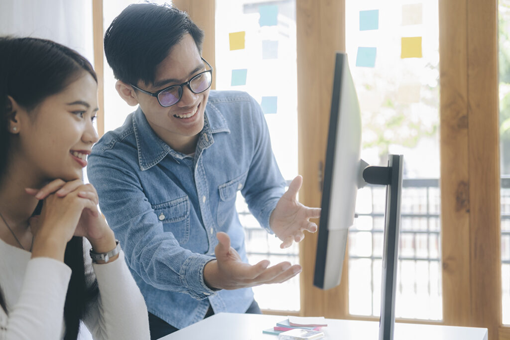 Two young executives discussion in front of computer.